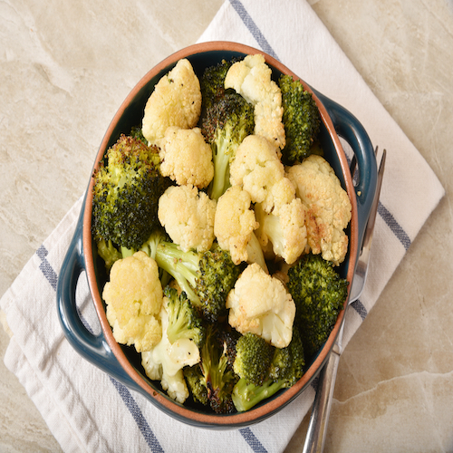 Overhead view of roasted cauliflower and broccoli with garlic