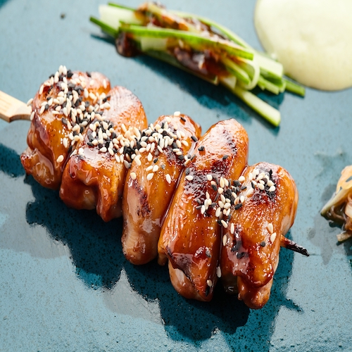 Traditional Japanese  food - skewer yakitori with chicken hearts and teriyaki sauce. Chicken skewer on bamboo stick in Japanese style. Bbq menu for asian restaurant. Yakitori on white background