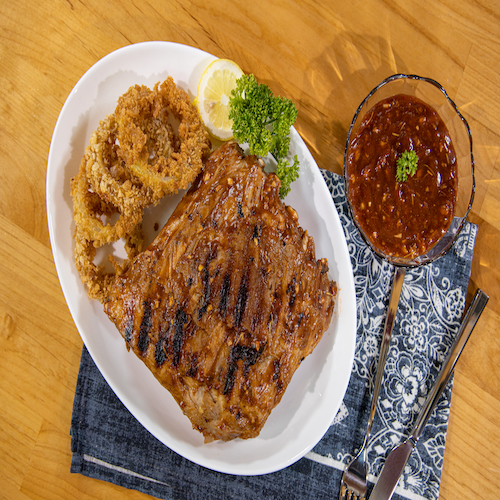 Grilled pork ribs with golden onions