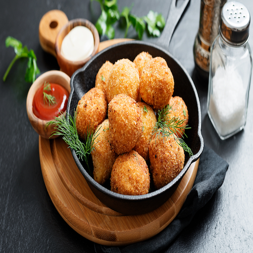 Potato croquettes - mashed potatoes balls breaded and deep fried, served with different sauce.