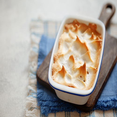 Homemade apple meringue pie in rustic baking dish copy space
