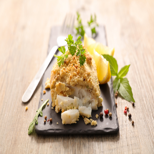 cooked fish with a crust and herbs