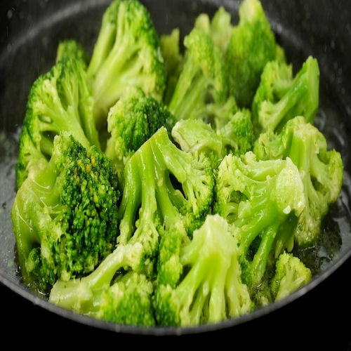 frying broccoli on a pan. Healthy food, vegetarian cuisine