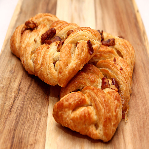 Apple and Pecan plait danish pastry on wooden board